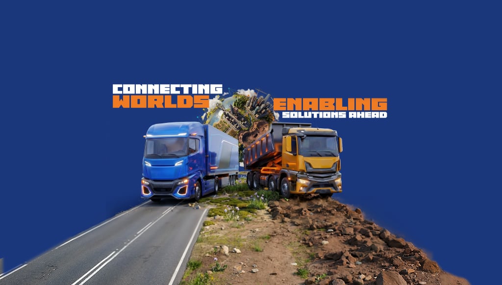 Two large trucks (blue semi and yellow dump truck) on road and rough terrain with a small globe and cityscape.